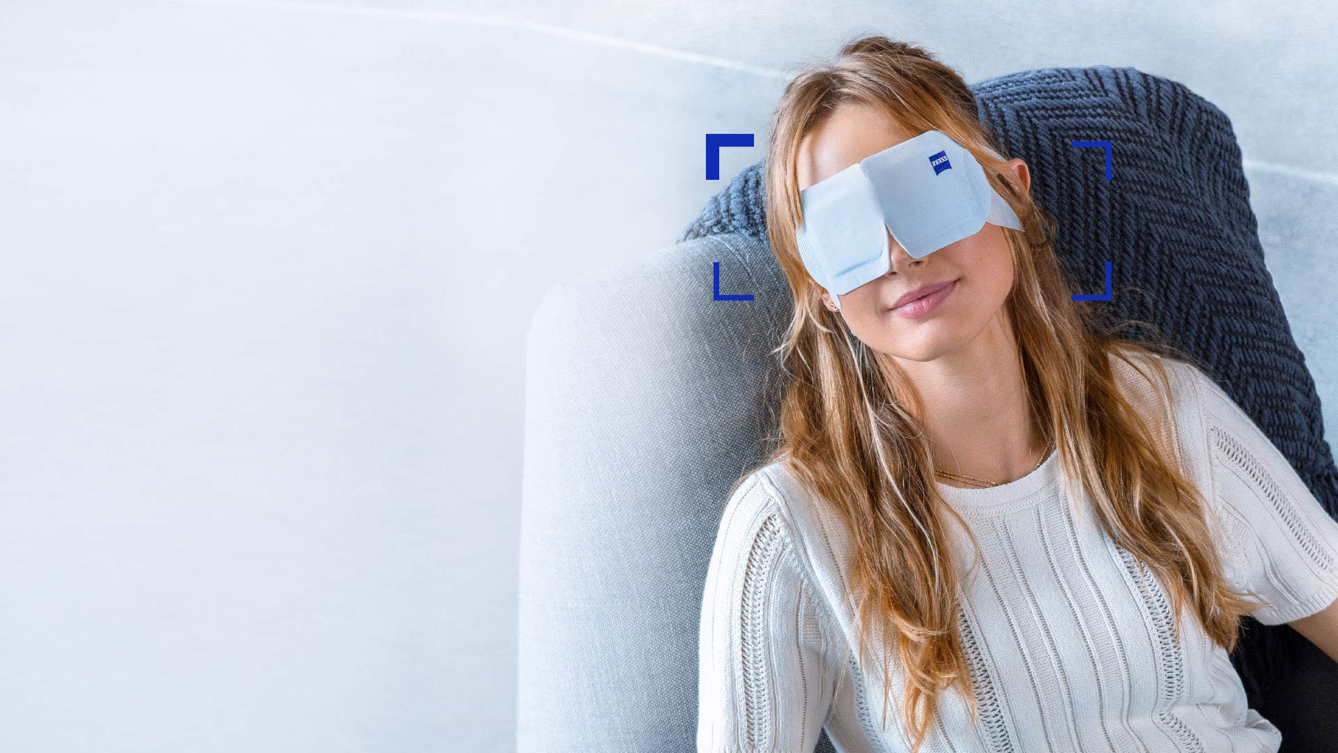 A women wearing ZEISS Warm Eye Mask and relaxing in a chair.